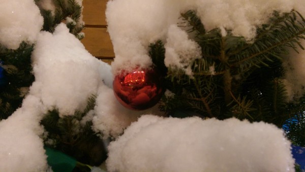 Ёлочный шарик на ёлке со снегом.